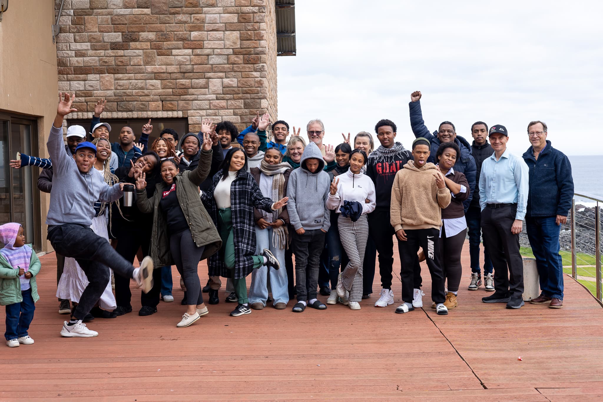 Young changemakers, mentors, and international faculty celebrating together on the conference deck