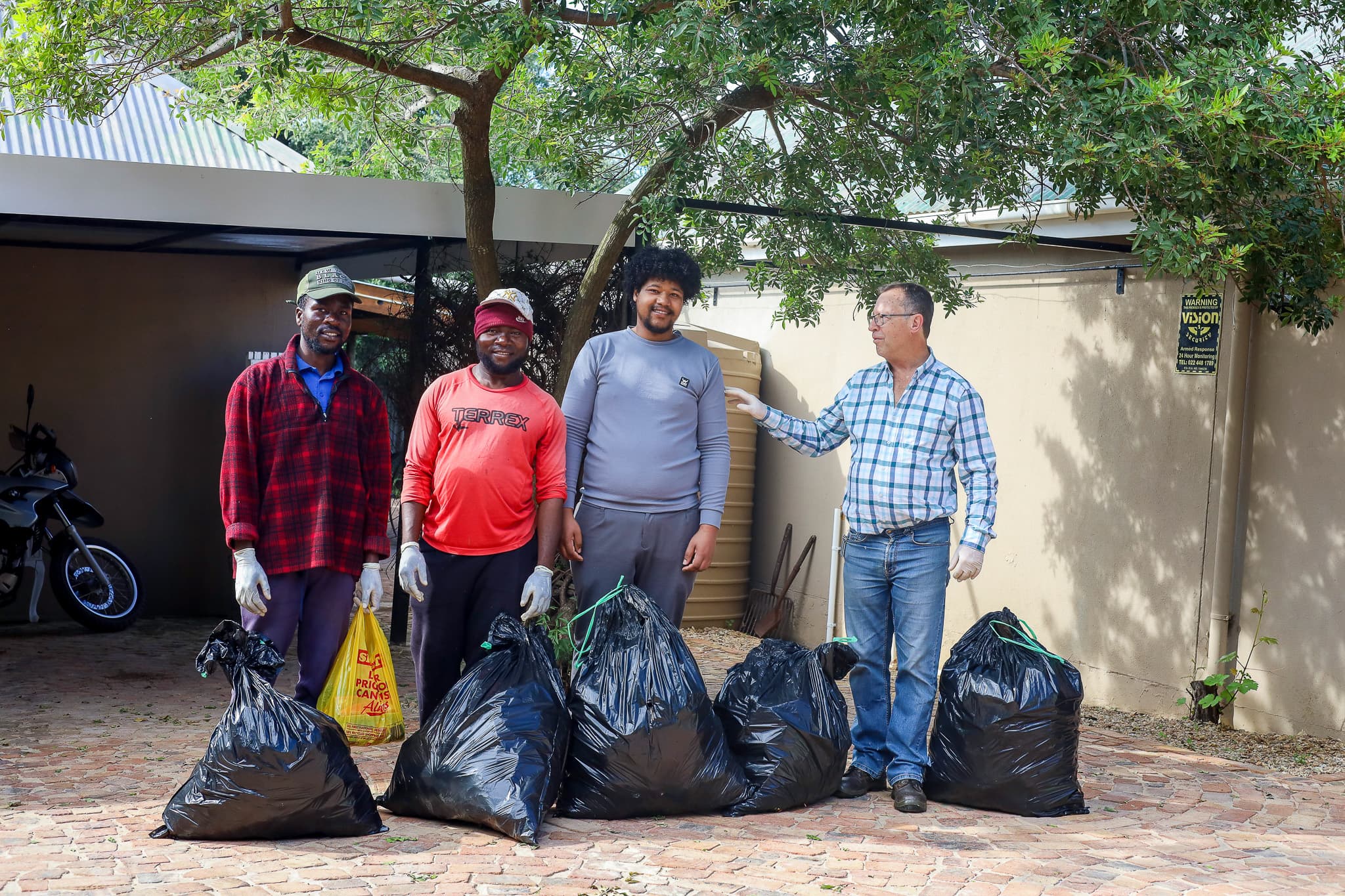 Dr. Nico de Klerk and young leaders smiling together following their International Day of Peace clean-up