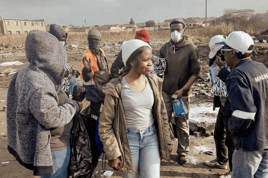 Volunteers and Nelsons collaborating in community cleanup and distribution